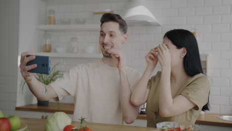 couple making a fun selfie in the kitchen