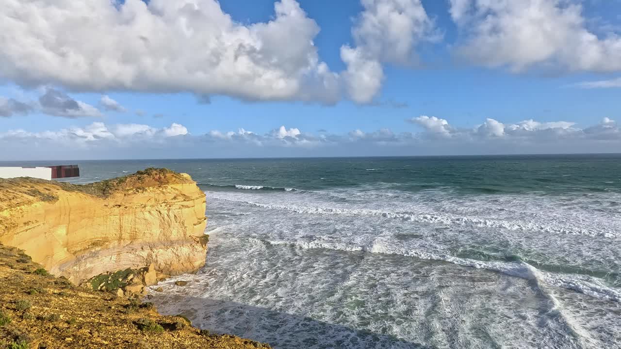 Fale oceanu rozbijające się o klify w słoneczny dzień