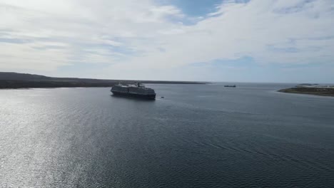 cruise ship sailing in calm waters near an island