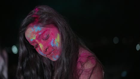joven india bailando con polvo de color seco holi explotando a su alrededor