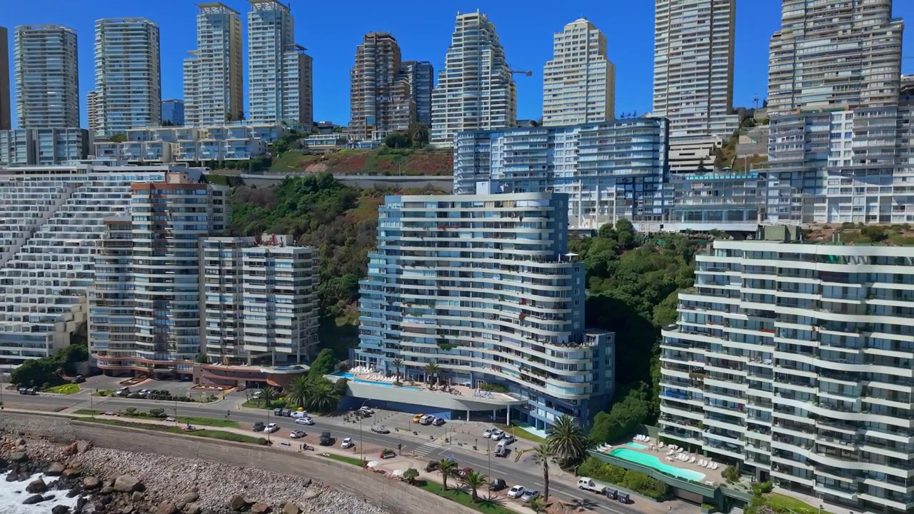 Órbita aérea panorâmica de edifícios residenciais modernos ao longo da costa de Concón, Chile, uma área à beira-mar com tráfego intenso