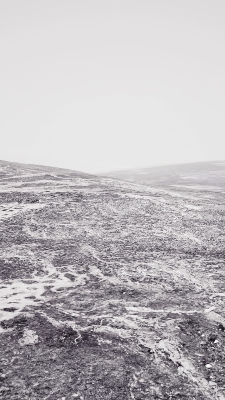 paisaje nevado con colinas y un cielo brumoso