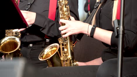 saxofonistas en una orquesta interpretando música en el escenario durante el concierto