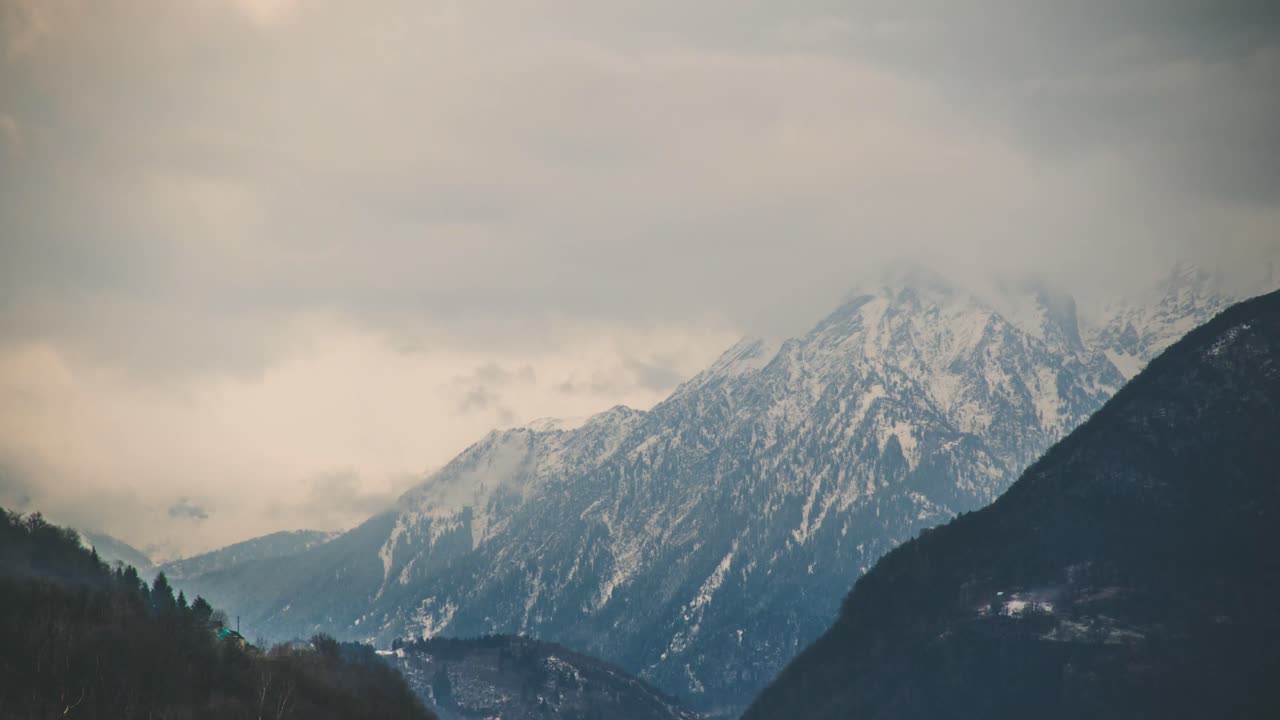 Timelpase of Large Snowy Alpine Mountain with Clouds Moving