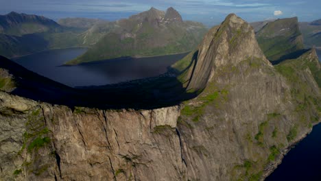 aerial panning shot of the famous segla mountain on senja island norway with a steep cliff face along the sea