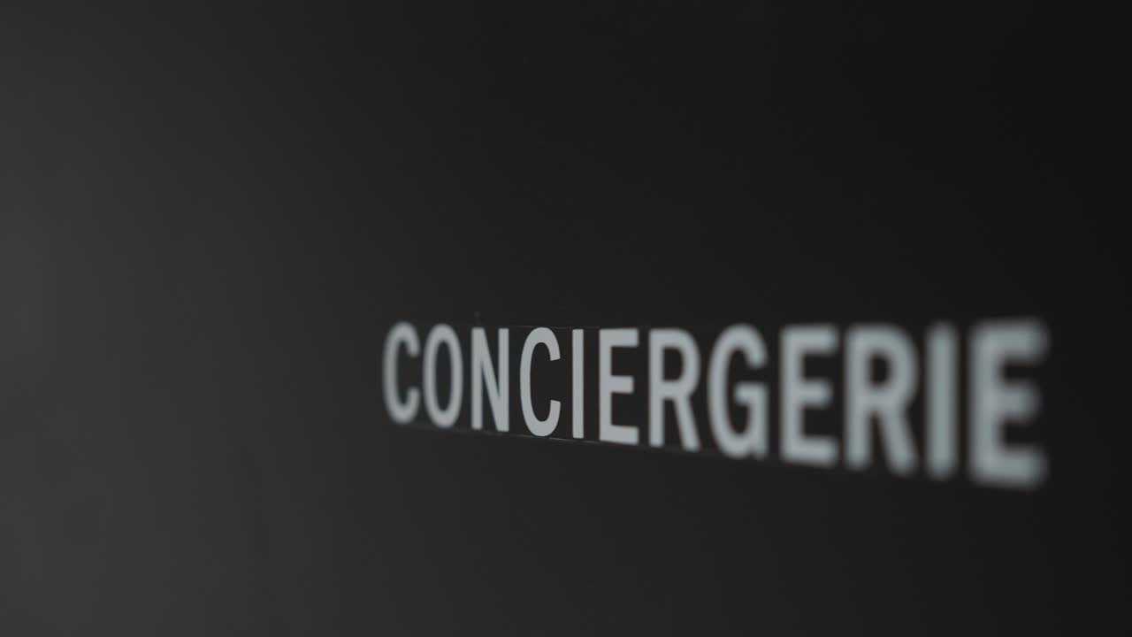 slow revealing shot of a concierge text on a wall inside of a hotel in France