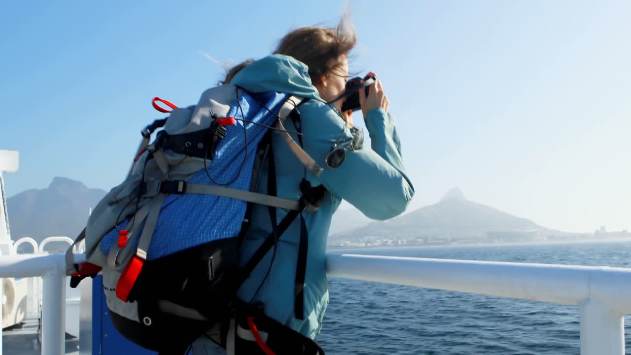 mujer haciendo clic en la foto con la cámara mientras viaja en ferry 4k