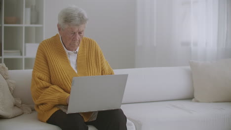 Senior-mature-older-woman-typing-a-message-on-the-keyboard-online-webinar-on-laptop-computer-remote-working-or-social-distance-learning-from-home.-60s-80s-businesswoman