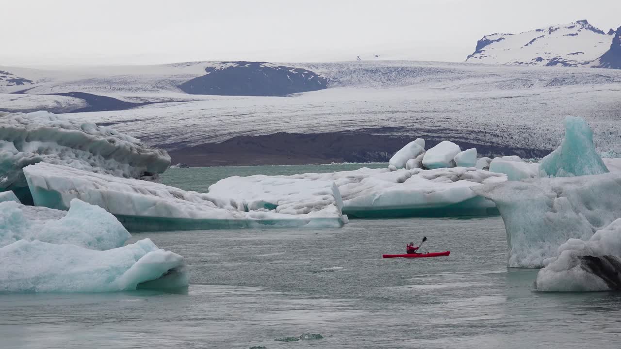 kayakers는 jokulsarlon iceland 1에서 녹는 빙하 석호를 통해 이동합니다.