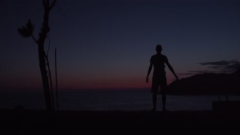 Männliche-Person-Breitet-Bei-Sonnenuntergang-Seine-Hände-Am-Strand-Aus