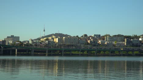 N-Seoul-Tower-In-Seoul-City-Yongsan-gu,-Verkehrsautos,-Die-Auf-Der-Rampe-Von-Der-Hannam-brücke-Zur-Gangbyeon-schnellstraße-über-Den-Fluss-Han,-Südkorea,-Fahren