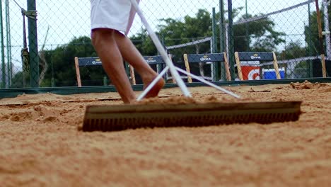 Close-Up-of-Beach-Tennis-Court-Sand-Raking-in-Slow-Motion
