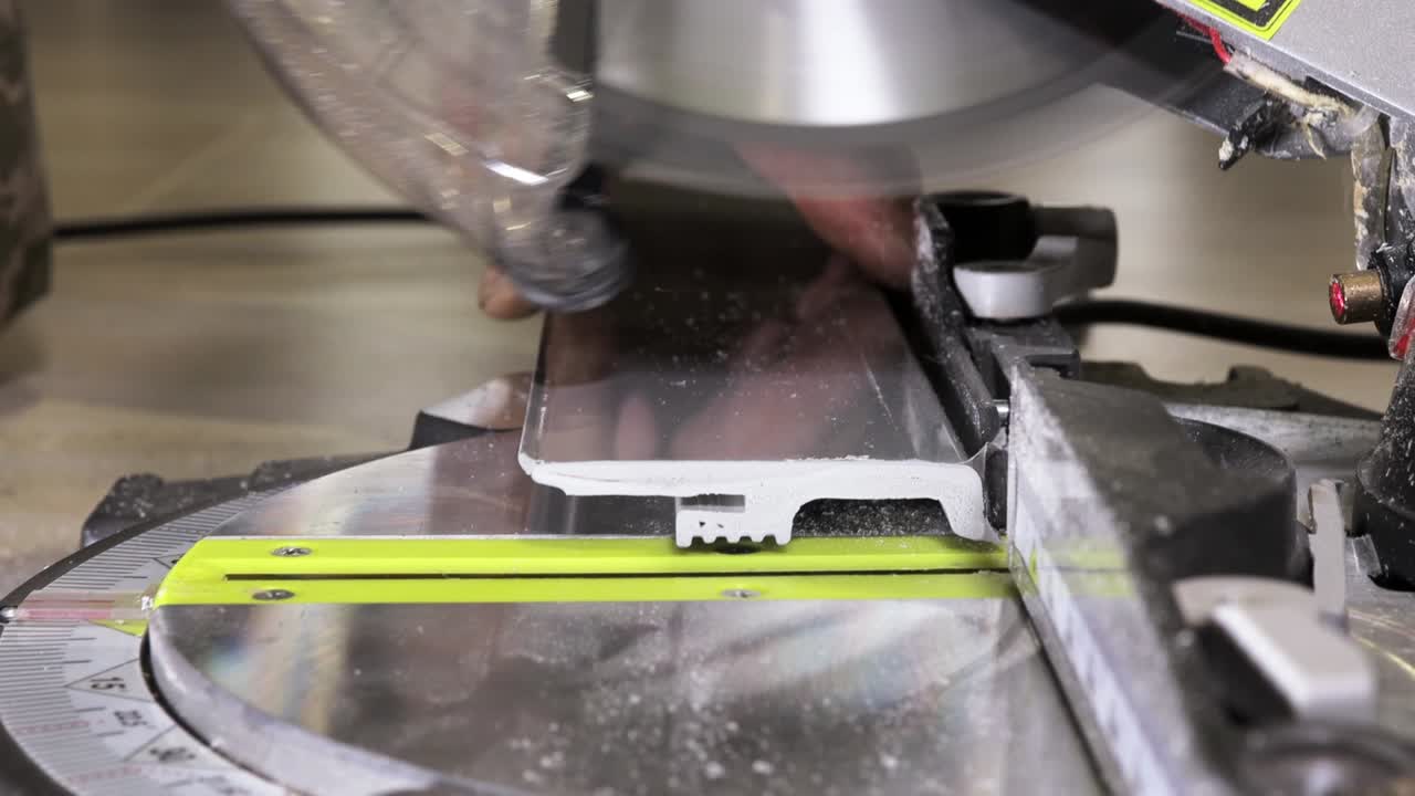 Worker cutting baseboard on the circular saw before installing.