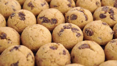 small round dessert cookies with chocolate chips stacked in rows