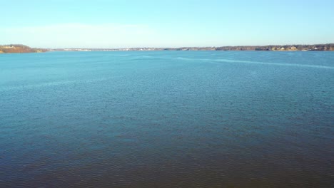 flying over calm blue water with ripples from wind on lake of the ozarks in midwest missouri at daytime - aerial drone shot