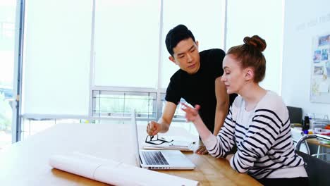 business executives discussing over laptop