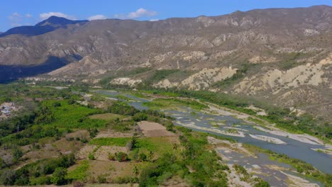 Vast-Mountain-Range-Landscape,-Farmland-of-Presa-Monte-Grande-and-Yaque-Del-Sur-River,-Dominican-Republic--Panning-Shot