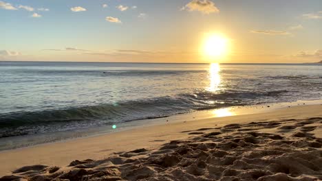 bright golden sun casts ray of light across open ocean as gentle waves crash on sandy shores of hawaii