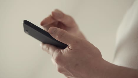 close up shot of a man's hands, who sends a message on a mobile phone