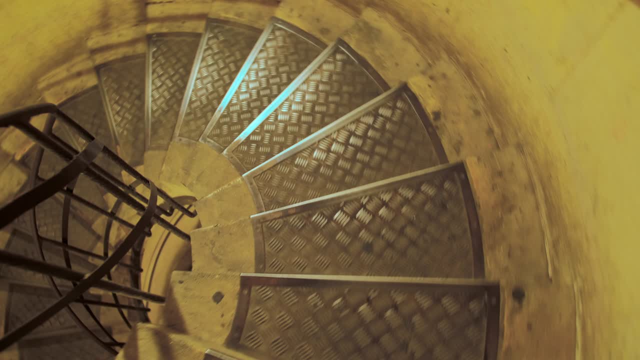 인식되지 않은 사람이 나선형 계단을 내려가고 있습니다. 느린 동작. 1인칭 시각