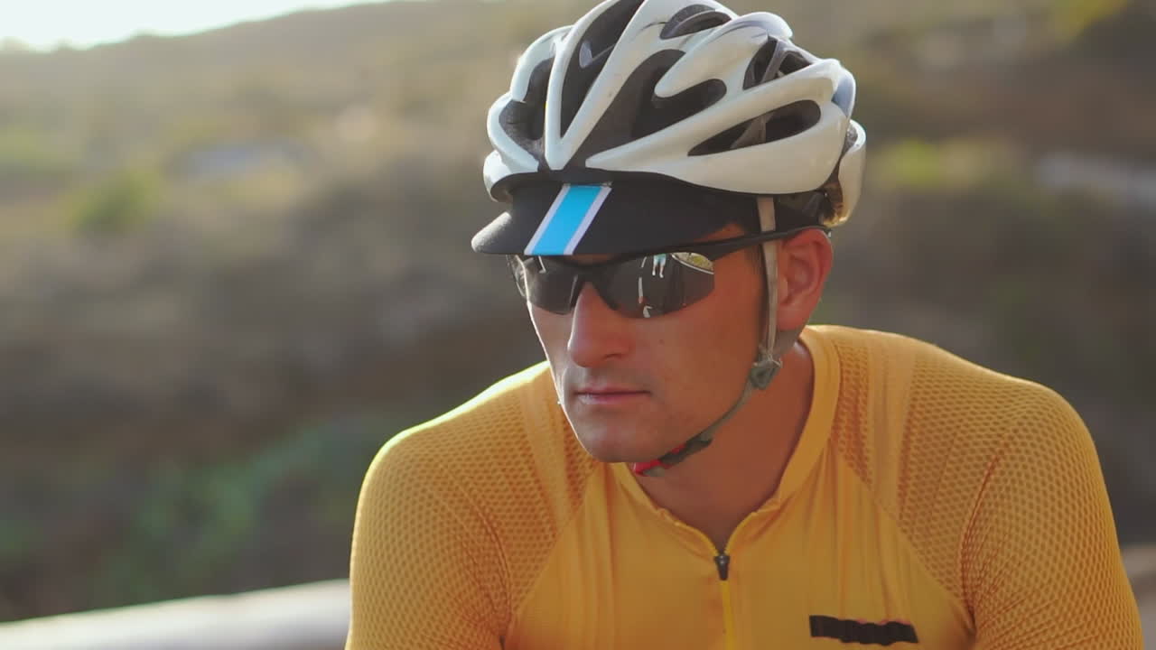 un ciclista masculino toma un momento para descansar a su llegada, mirando con asombro el panorama montañoso