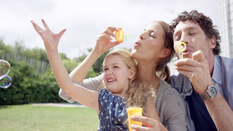 Happy-family-blowing-bubbles-in-the-yard-at-home