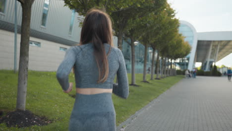 mujer corriendo en un parque urbano
