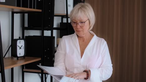 older woman reviewing documents in an office environment
