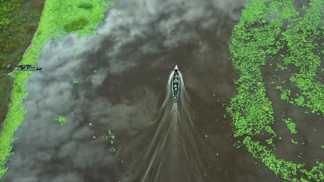 people traveling by boat on amazon river in peru - aerial drone view