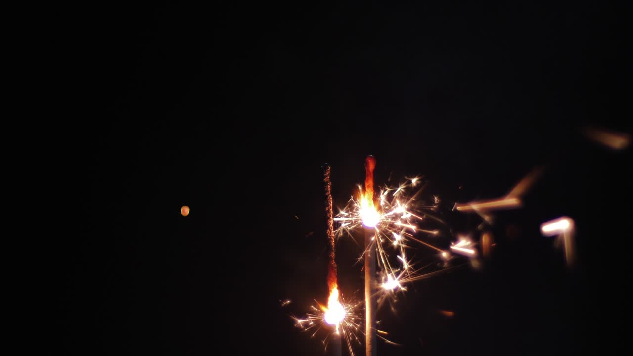 Bengal fire on black background, burning sparklers light
in celebration Video Clip stock footage.