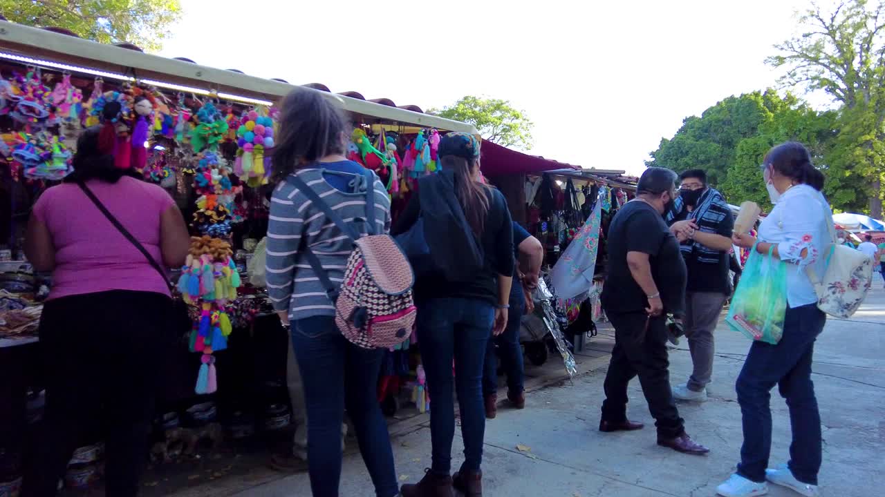 Local craftsman shops at the downtown city square with tourist wearing masks during the pandemic. Happy family leisure moments. Latin-america