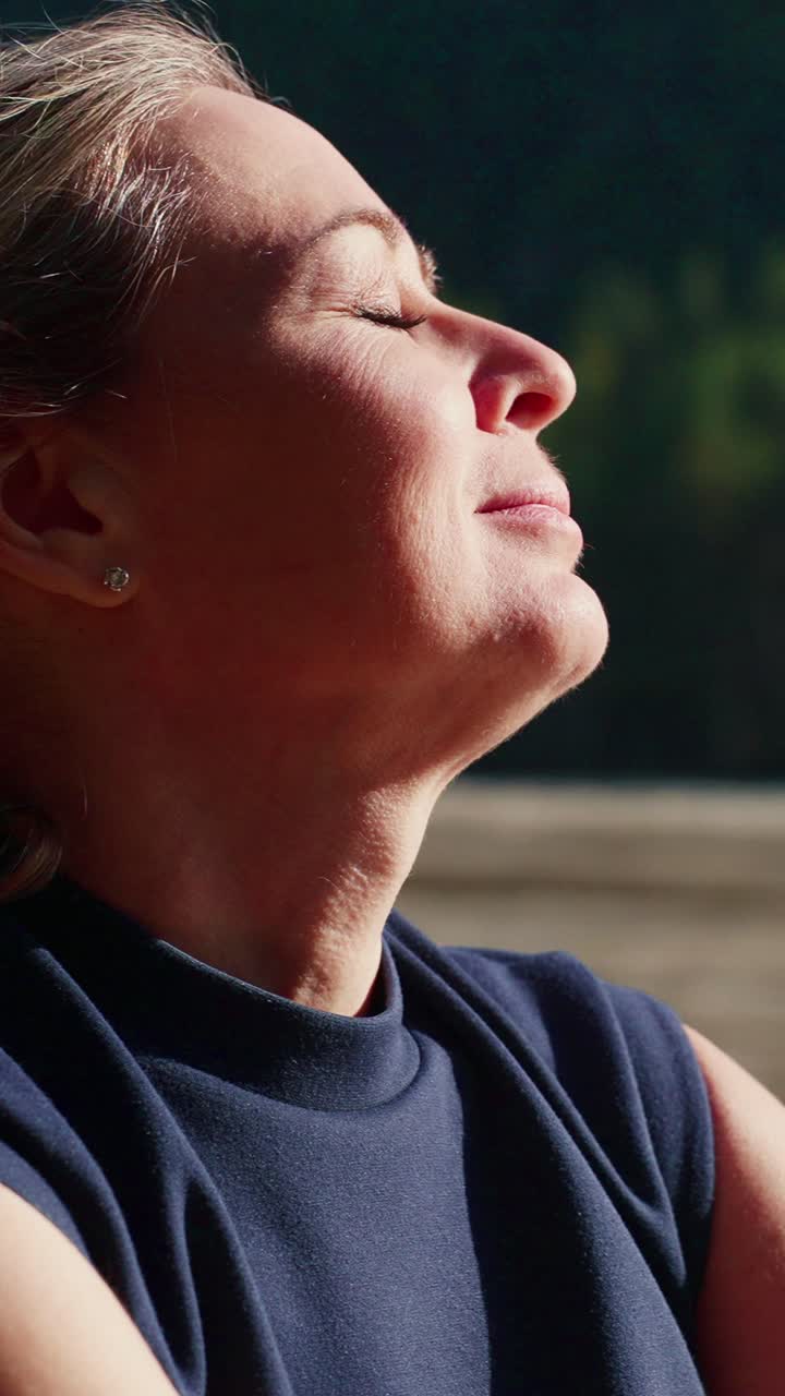 A luz suave do sol ilumina o rosto dela. Os olhos dela estão delicadamente fechados. Ela se reclina, relaxada e calma. A luz quente realça sua expressão pacífica. Perfeito para cenas de bem-estar ou relaxamento.
