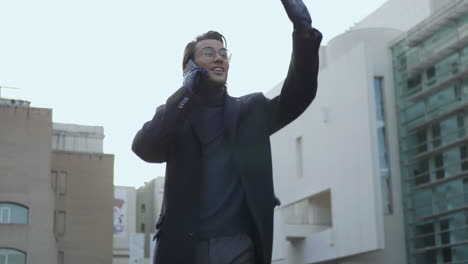 Hombre-De-Negocios-Sonriente-Llamando-Por-Teléfono-En-La-Calle.-Feliz-Ejecutivo-Caminando-Al-Aire-Libre