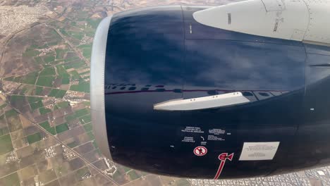 shot-of-airplane-window-seat-with-turbine-crossing-mexican-desert-of-chihuahua