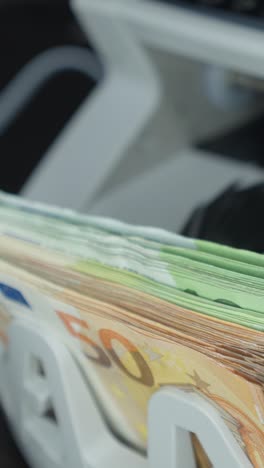 euro banknotes being counted by a machine