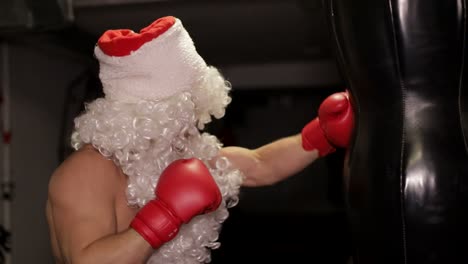 santa claus beats boxing bag angry santa claus santa claus kickboxer training in the gym the concept of sport
