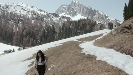 woman trekking on snowy slope in dolomite mountain range in south tyrol, italy