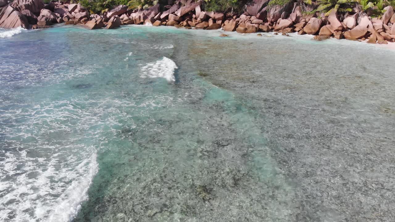 Seyşeller'in bir adası olan La Digue'deki Anse Coco, Petit Anse ve Grand Anse'deki ıssız, beyaz plajlara doğru yuvarlanan dalgaları takip eden hava görüntüsü.