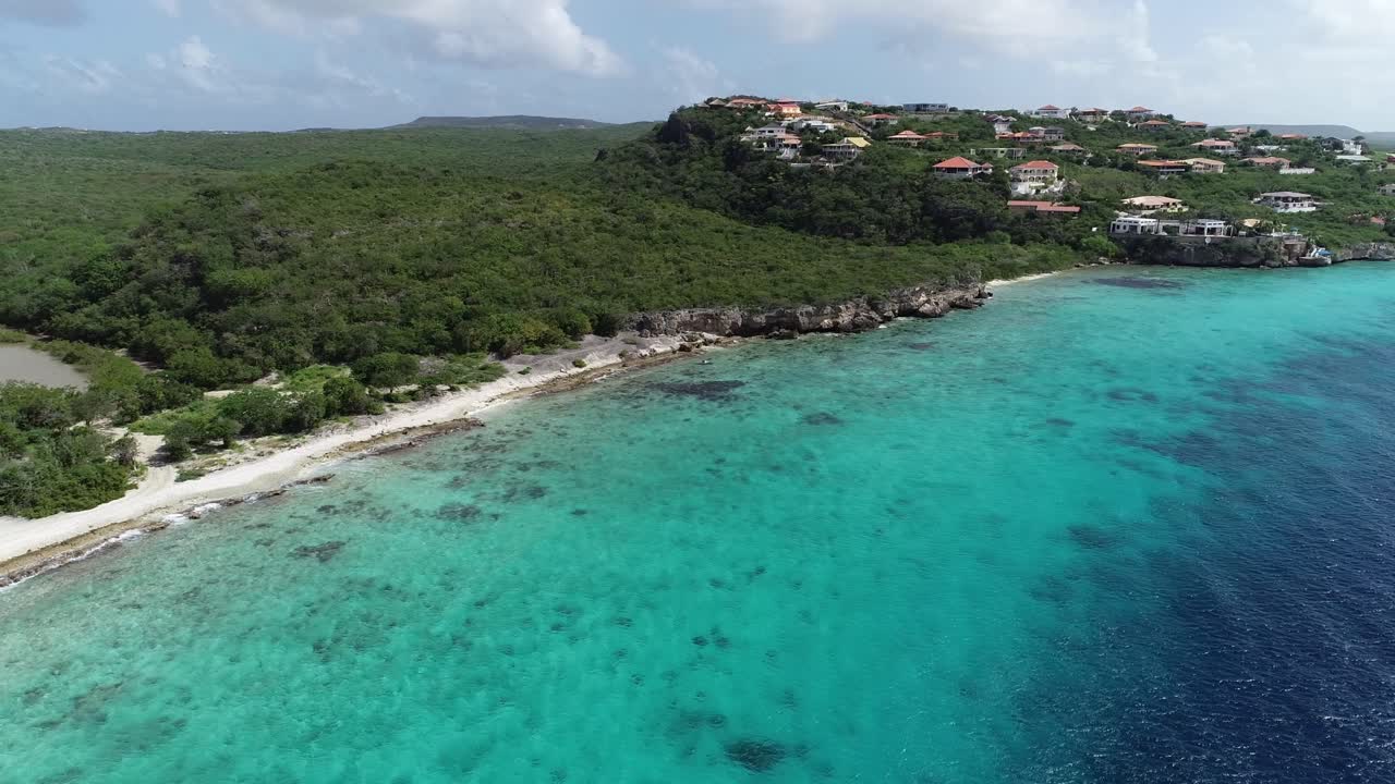drone che vola via dall'isola con acqua cristallina dell'oceano e vegetazione