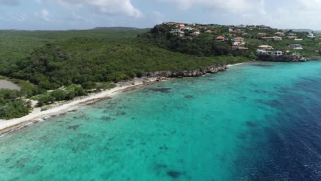 drone volando lejos de la isla con agua clara del océano y vegetación