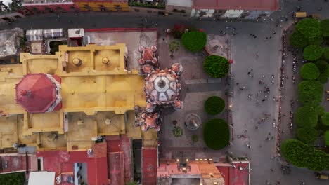 rising drone shot showing tourist on square visiting mexican cathedral in san miguel de allende, guanajuato