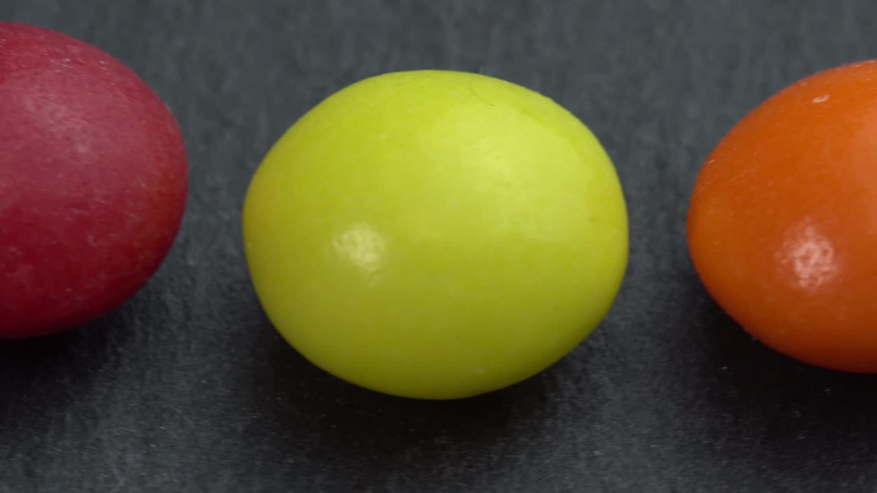 dulces de colores cerrar girar en un fondo negro, dulces de color macro