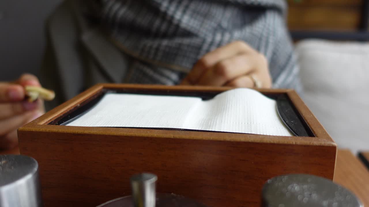 테이블 위 에 있는 나무 상자 에서 킨 을 당기는 사람 의 근접 촬영