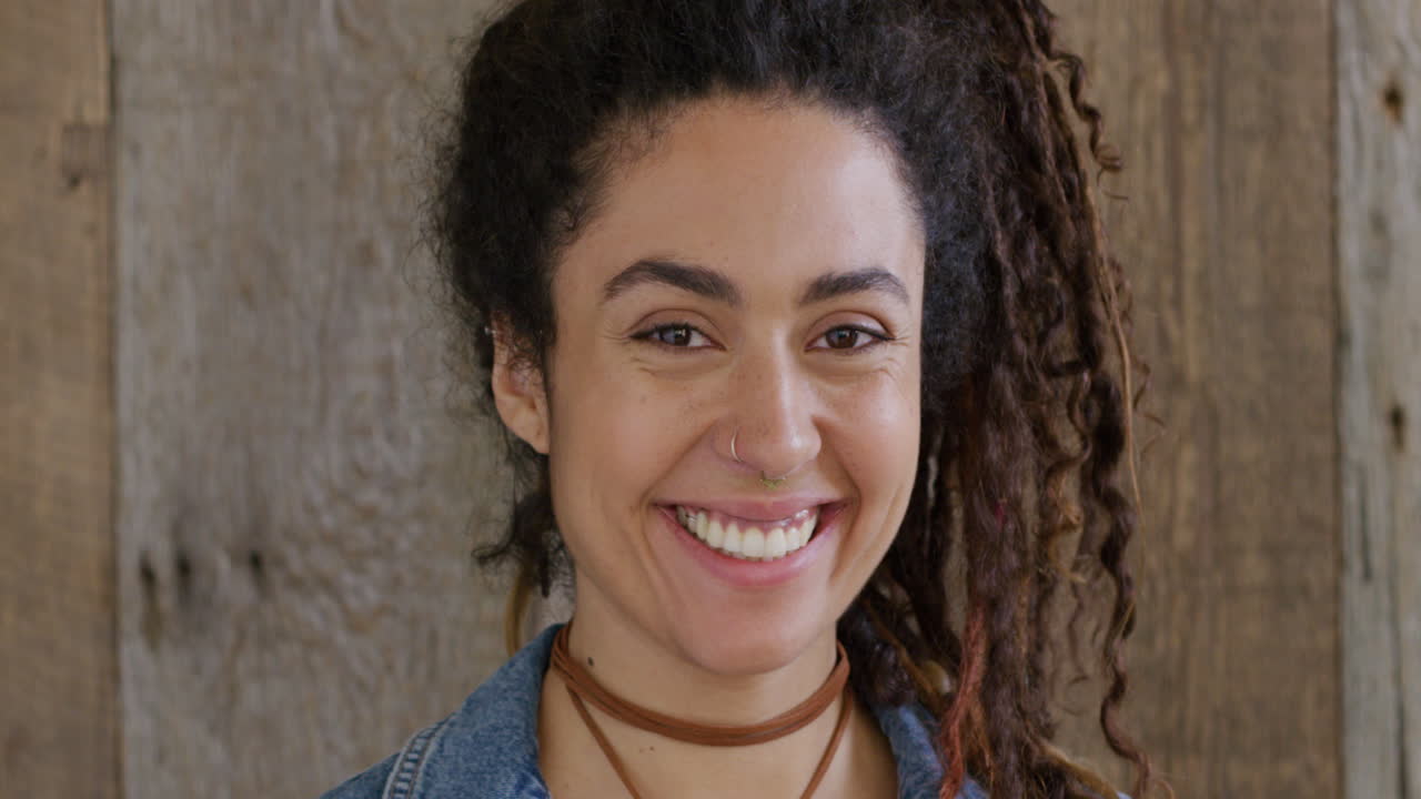 retrato de mujer de raza mixta con dredlocks sonriendo