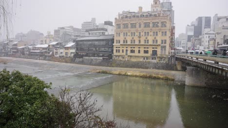 Kyoto-Gion-Shijo,-Winter-Scene-as-Snow-Falls-over-Kamo-River-on-Chilly-Day