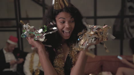 pretty black girl making funny faces, dancing, throwing confetti at new year's eve party