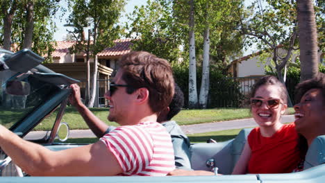 Young-adult-friends-on-the-road-in-a-convertible,-close-up