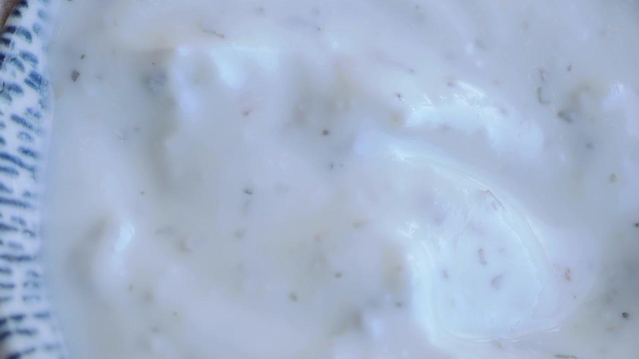 Primo piano di salsa cremosa alle erbe in una ciotola.