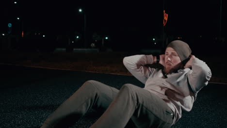 man doing sit-ups outdoors at night