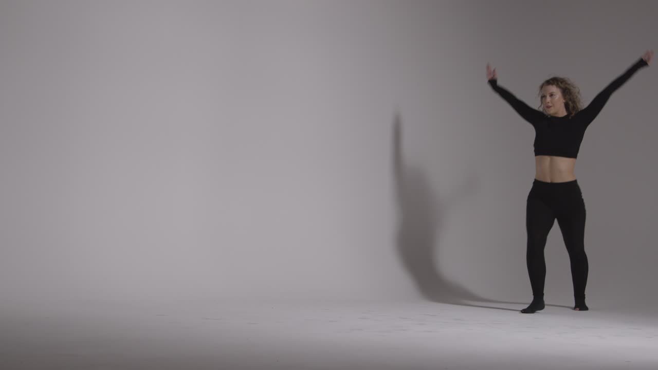 foto de estudio de longitud completa de una mujer joven haciendo práctica de baile contra un fondo gris 4
